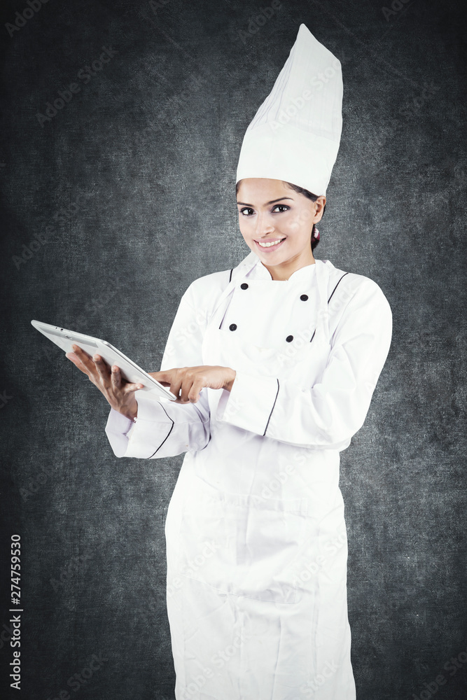 Beautiful chef using a tablet in the studio Beautiful chef using a tablet in the studio
