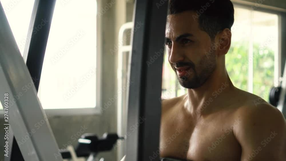 Muscular young Caucasian man doing seated back row machine exercise at the gym Muscular young Caucasian man doing seated back row machine exercise at the gym
