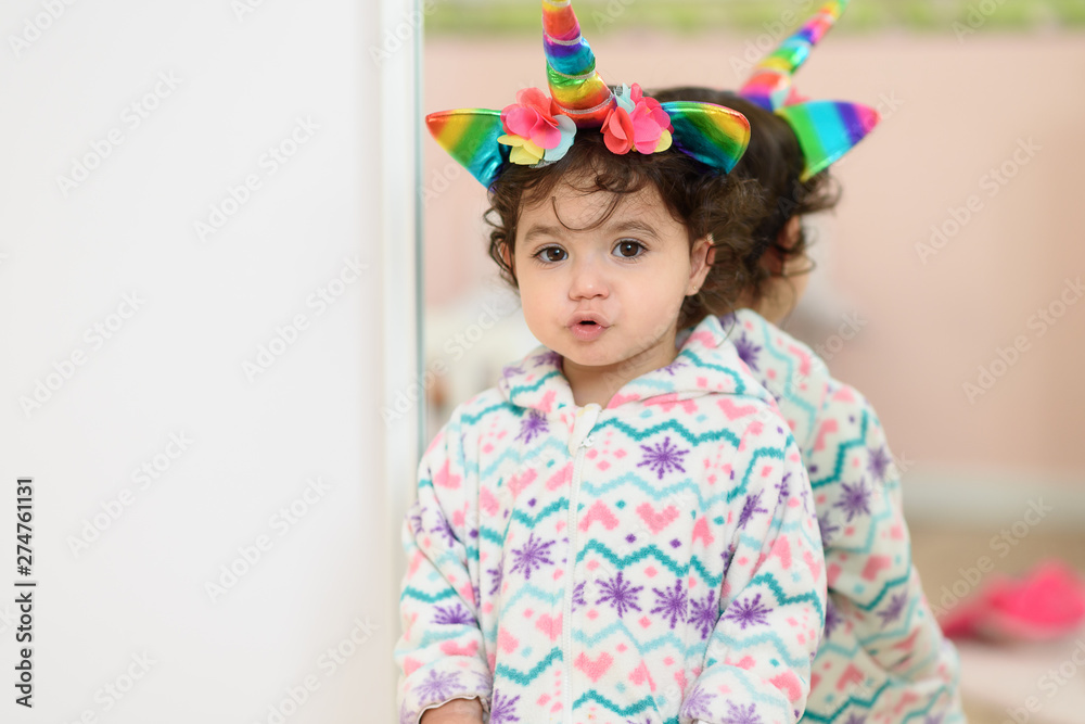 Cute little girl child plays unicorn in the kids room. Cute little girl child plays unicorn in the kids room.