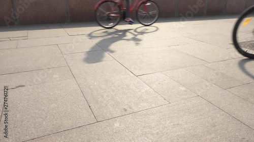 Unrecognizable cyclist riding bike down urban city street. Side down view of irrecognizable people cycling. Healthy lifestyle concept photo