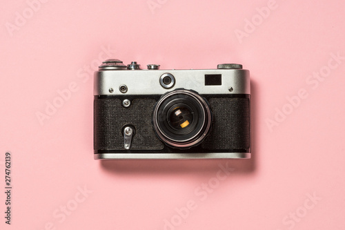 Old film camera on pink background. photo