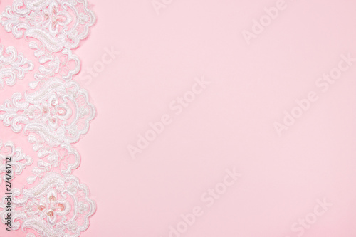 Beautiful white floral lace on a pink background.