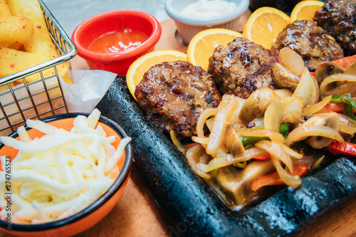 Grilled or roasted minced meat or meatballs food meal and vegetables with french fries potatoes in cafe or restaurant. Dinner or lunch table concept image