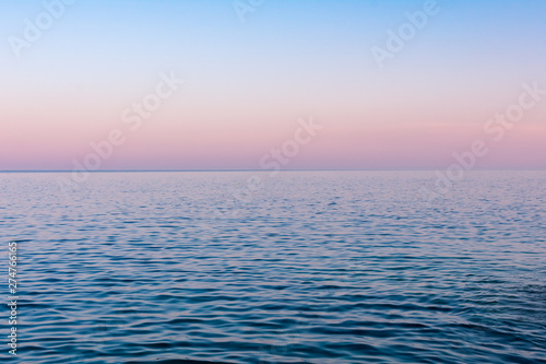 Seascape background, a hazy colorful sunset after a hot summer day over calm sea water, Vis island, Croatia © IKA