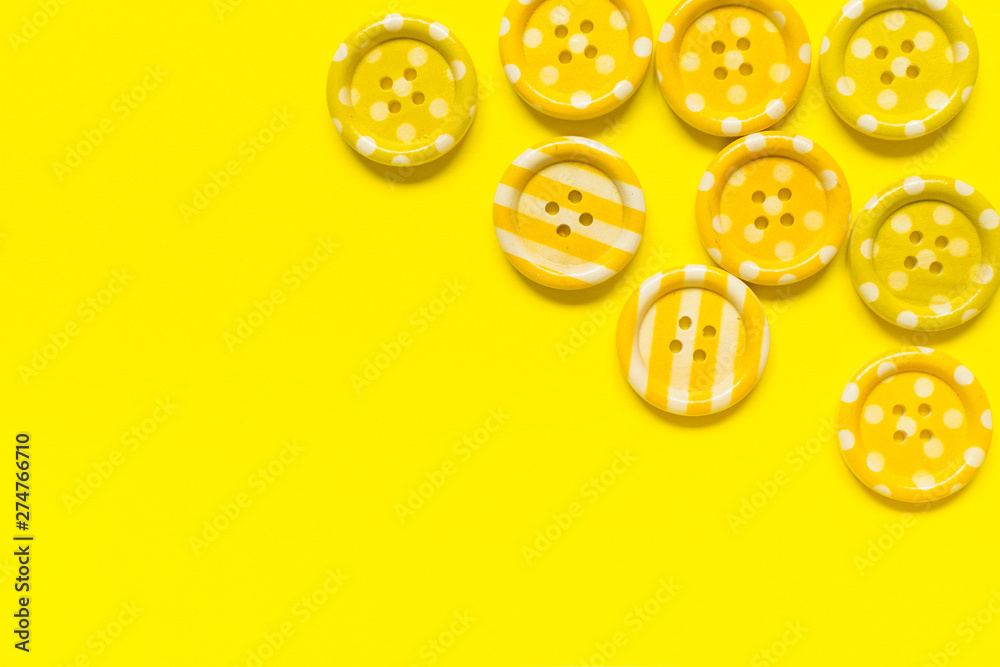 Fototapeta premium Various yellow sewing buttons on yellow background