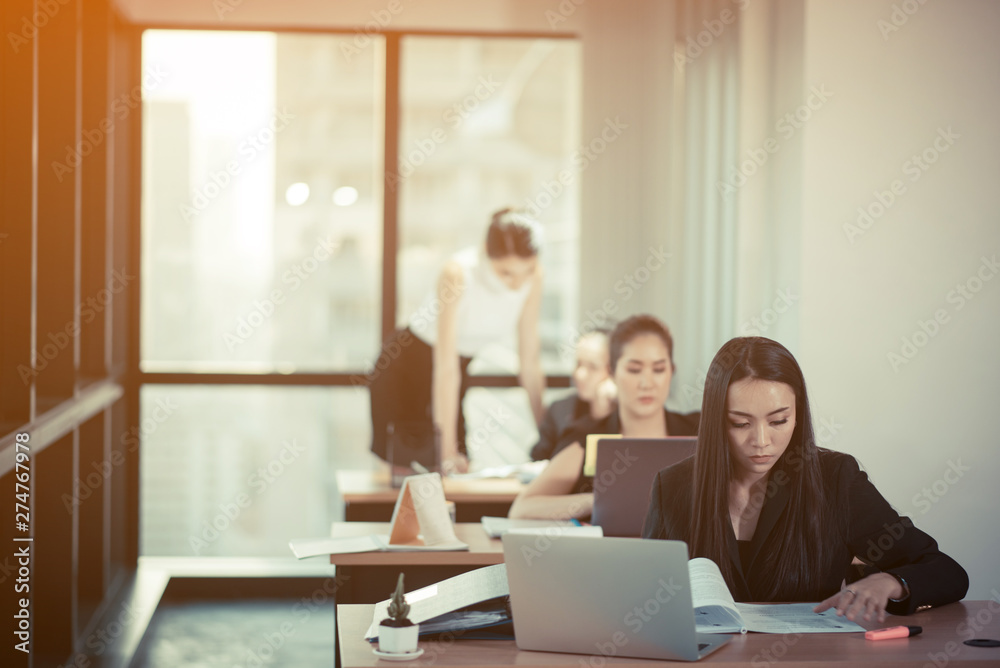 Shot of a beautiful young businesswoman using laptop and doing some paperwork while working on laptop Shot of a beautiful young businesswoman using laptop and doing some paperwork while working on laptop
