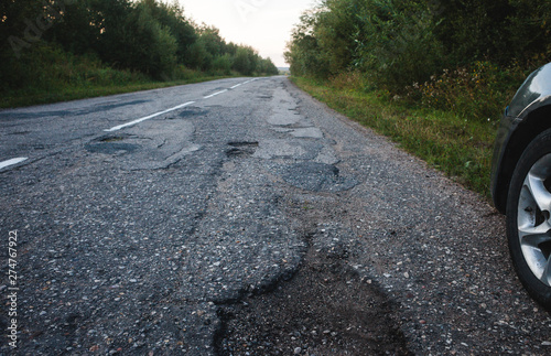 Fotografía The car damaged the suspension due to poor asphalt and potholes