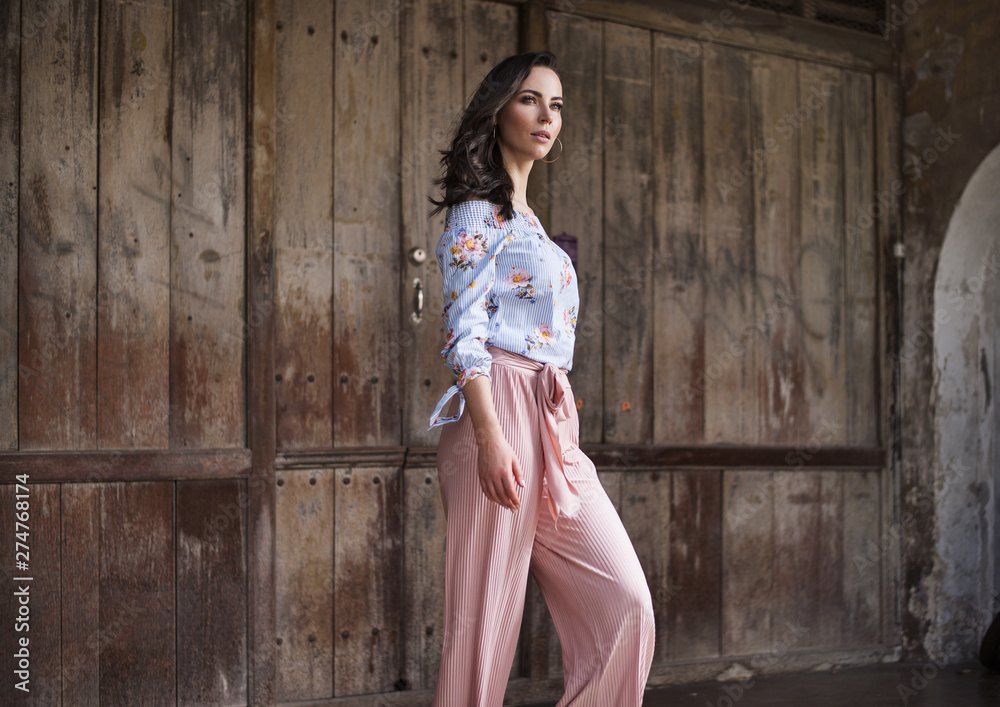 Natural brunette lady posing in front of the wooden gate