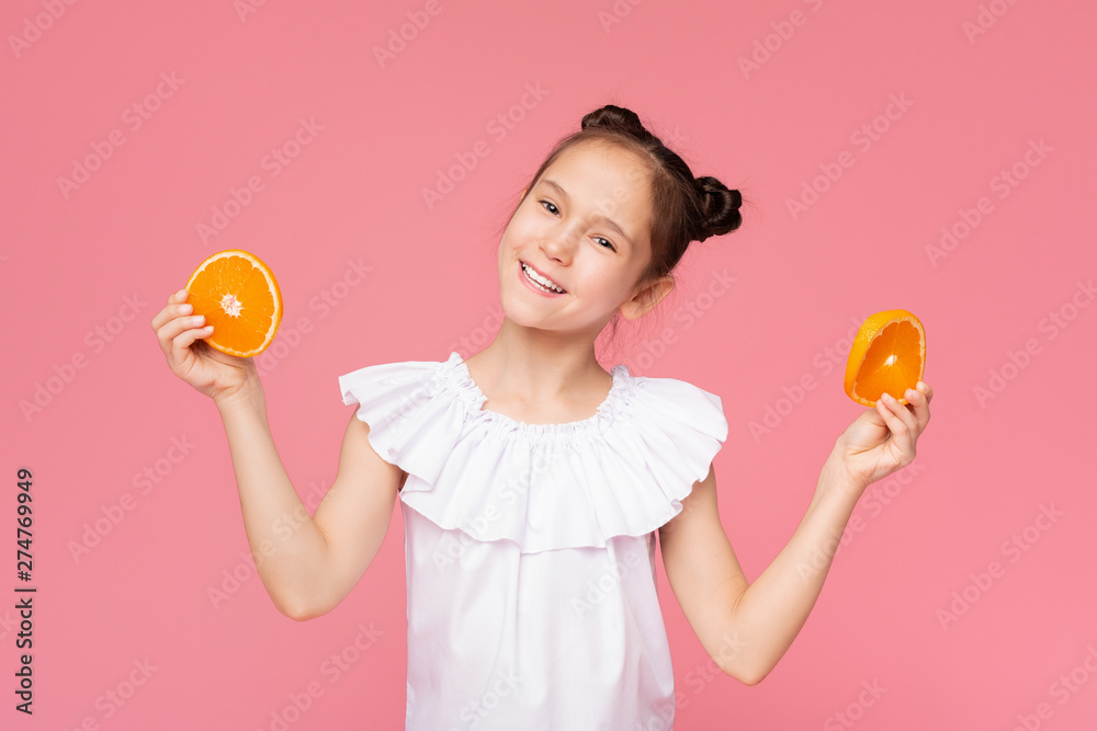 Adorable little girl holding fresh orange slices, enjoying citrus fruit Adorable little girl holding fresh orange slices, enjoying citrus fruit
