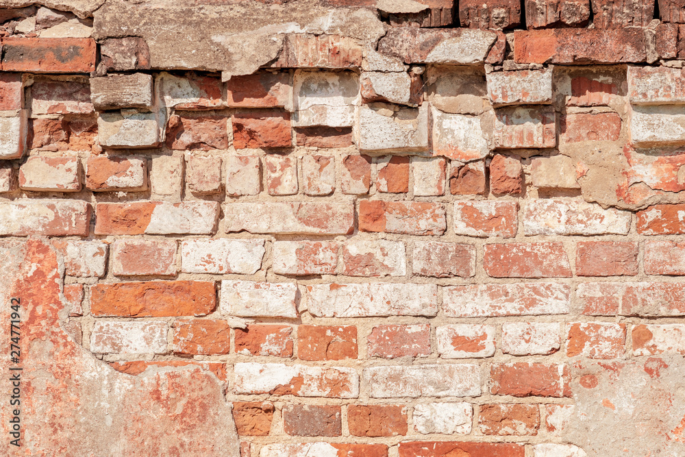 Obraz premium abstract background of an old brick wall with peeling plaster close up