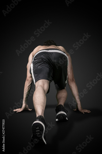 Rear view of a muscled man ready to run