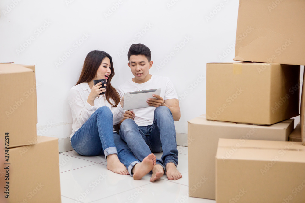 Romantic couple using a tablet in a new house