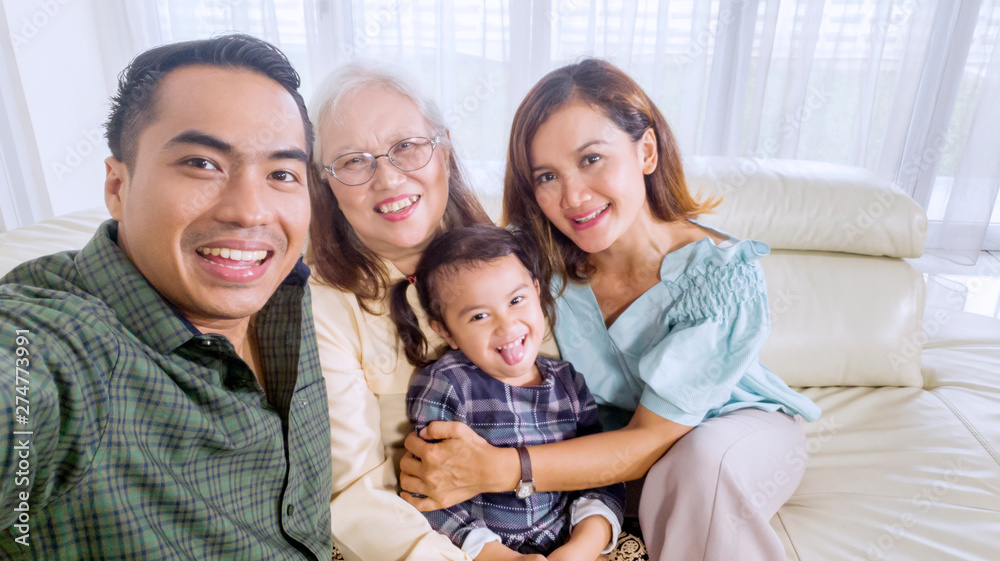 Smiling family takes a group picture at home