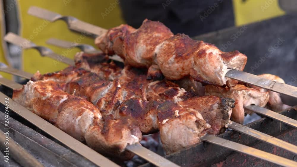 pieces of barbecue meat on skewers in the park, a male cook in nature is cooking pork roast meat with spices pieces of barbecue meat on skewers in the park, a male cook in nature is cooking pork roast meat with spices