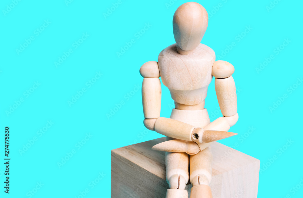 Wooden human figure on a blue background. Concept of abdominal pain, artificial intelligence. Wooden human figure on a blue background. Concept of abdominal pain, artificial intelligence.