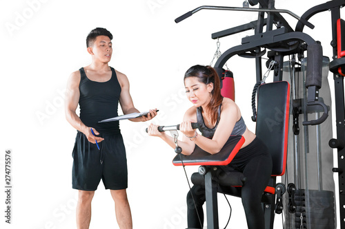 Woman uses exercise machine with her trainer