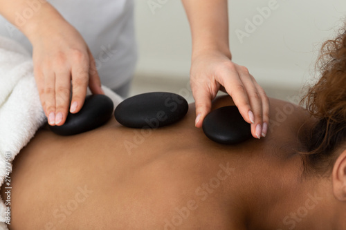 Stone Massage. Woman Receiving Hot Back Massage