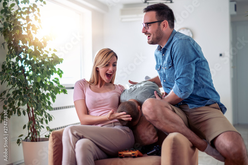 Parents with son having fun at home © ivanko80