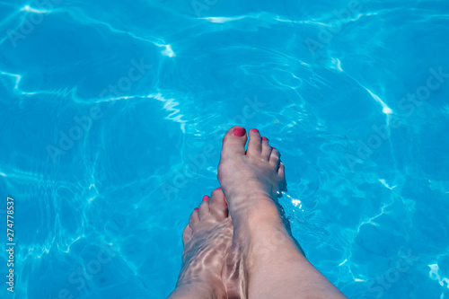 woman's feet splashing in the pool © Maria