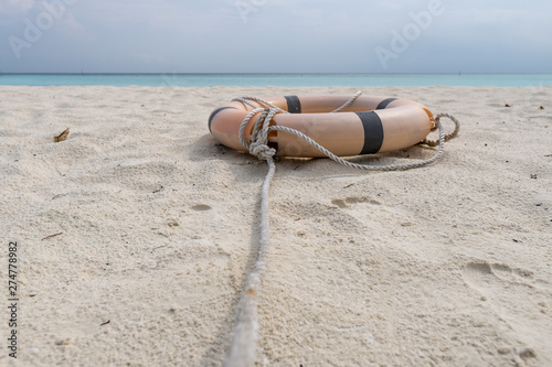 Lifebuoy and rope lie on the beach of a tropical beach.