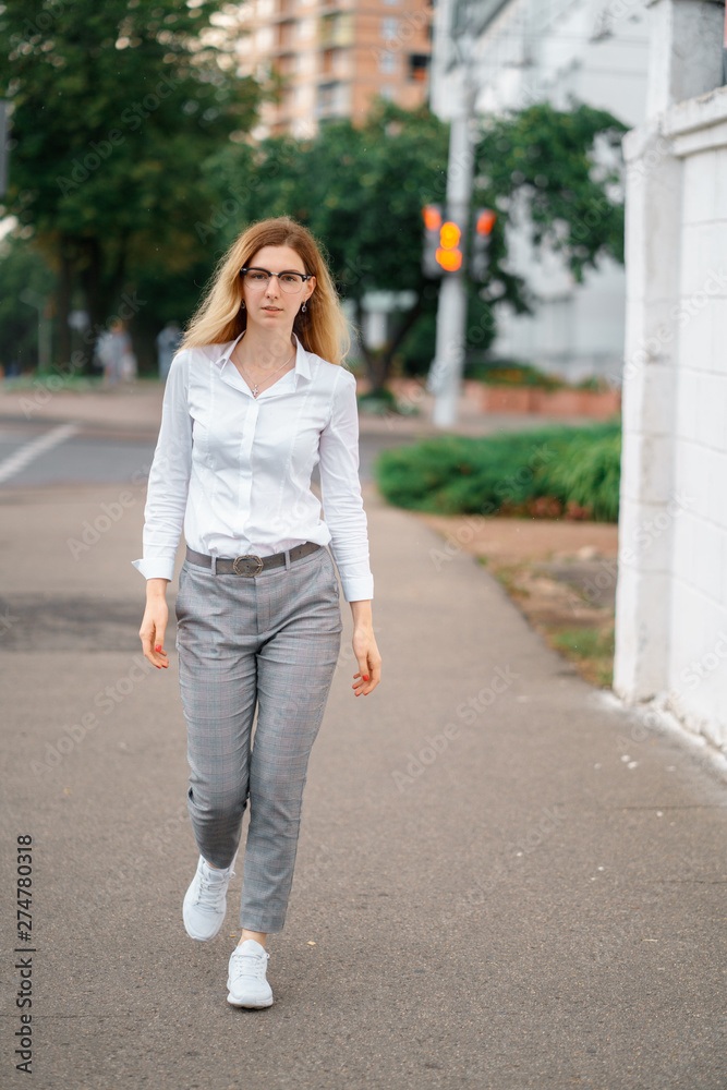 young beautiful woman walk on street spend time on fresh air