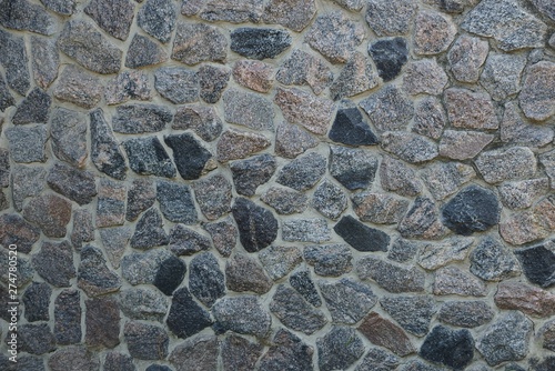 gray stone texture of large cobblestones in the wall of the fence