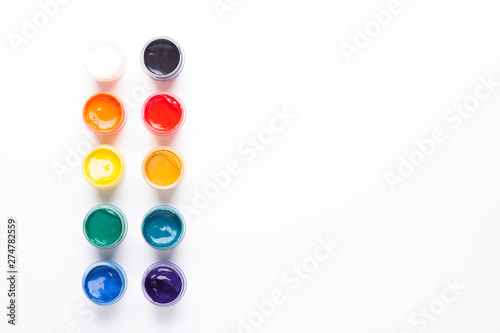 Containers with paints on a white background Multicolored gouache Isolated Top view