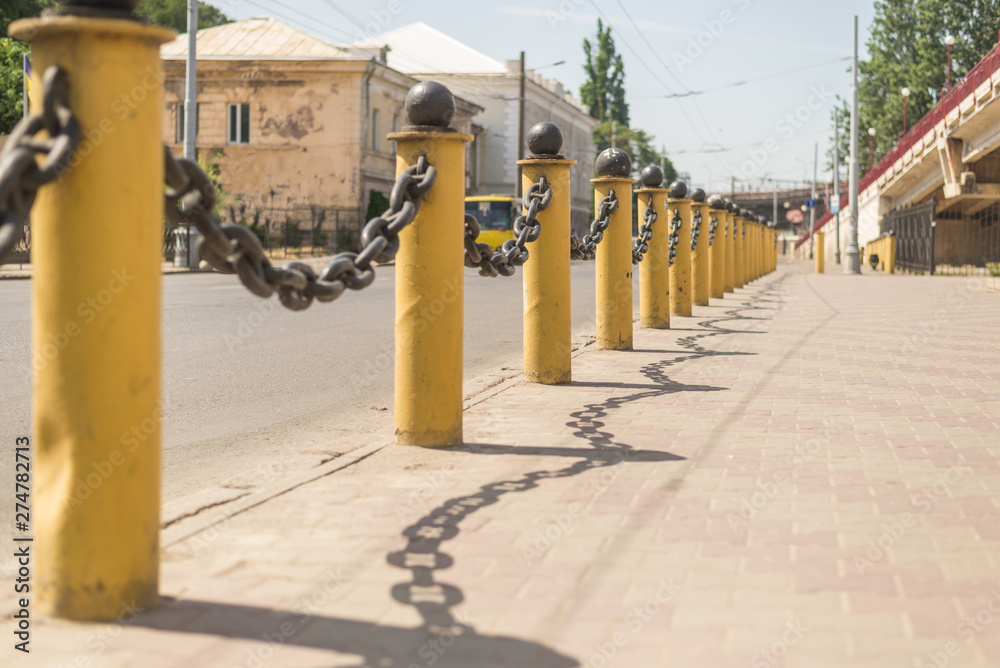 Fencing thick chain on yellow pillars along the road. Fencing thick chain on yellow pillars along the road.