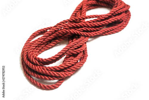 Red jute rope for shibari isolated on white background.