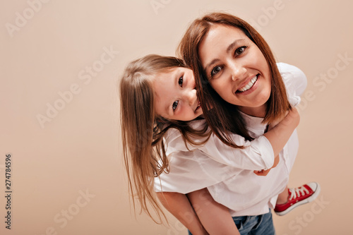 Close-up portrait of smiling happy woman with daughter wearing white shirts have fun and enjoying free time