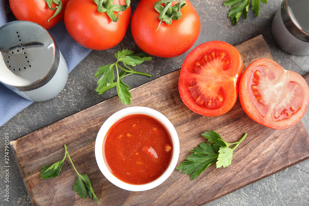 Flat lay composition with bowl of sauce and tomatoes on grey table Flat lay composition with bowl of sauce and tomatoes on grey table