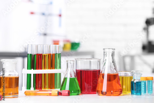 Different glassware with samples on table in chemistry laboratory