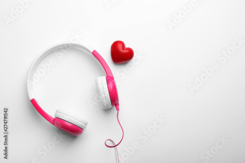 Decorative heart and modern headphones on white background, top view