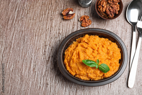 Flat lay composition with mashed sweet potatoes on brown background, space for text