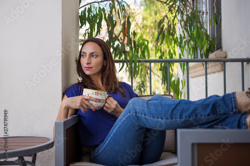 woman looking outside withc cup of coffee photo