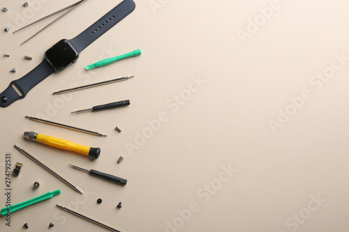 Flat lay composition of broken smart watch and tools on color background, space for text. Repair service