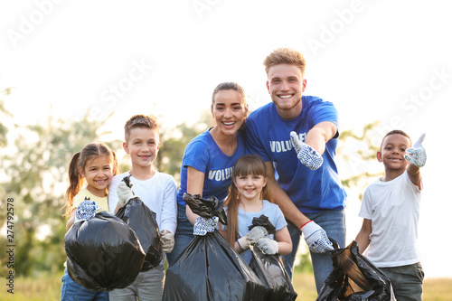 Volunteers and kids with bags of trash in park
