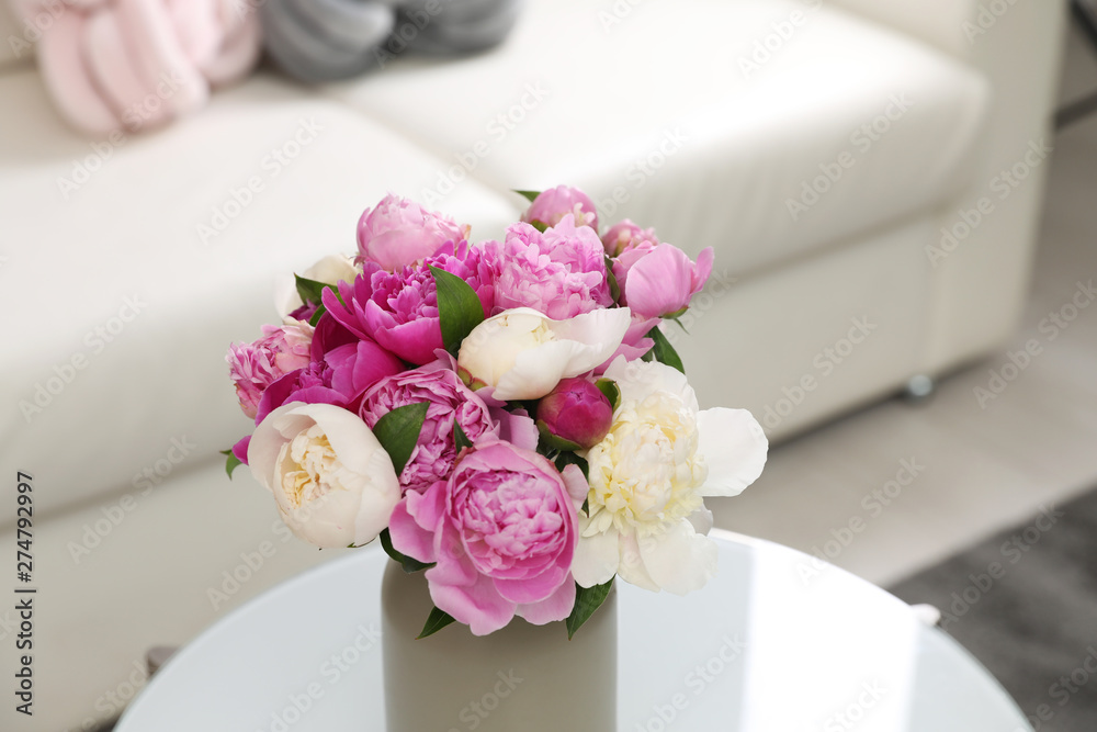 Vase with bouquet of beautiful peonies on table in room Vase with bouquet of beautiful peonies on table in room