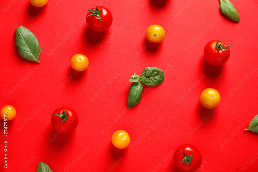 Flat lay composition with ripe cherry tomatoes and basil leaves on color background Flat lay composition with ripe cherry tomatoes and basil leaves on color background