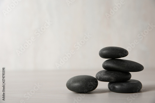 Black spa stones on light background. Space for text