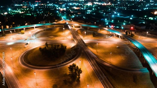 Hyperlapse timelapse of night city traffic fast cars driving around the roundabout on the highway photo