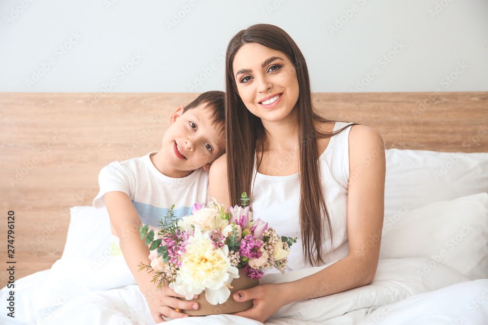 Young mother and son with bouquet of beautiful flowers at home Young mother and son with bouquet of beautiful flowers at home