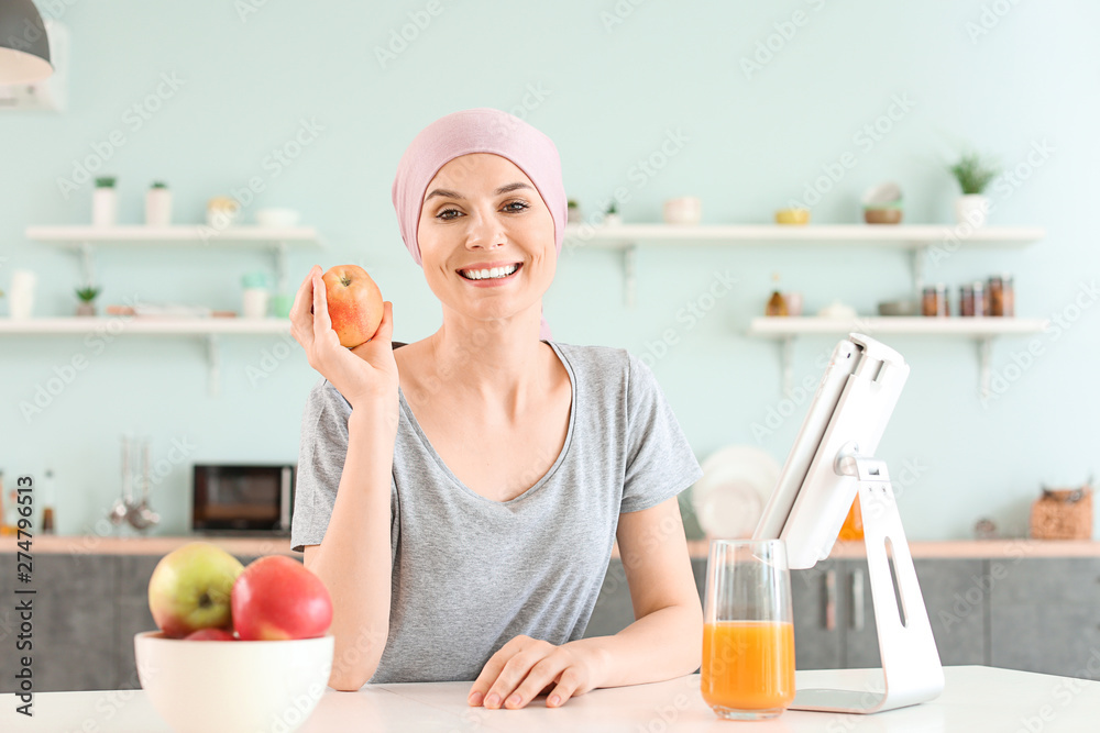Woman after chemotherapy in kitchen at home Woman after chemotherapy in kitchen at home