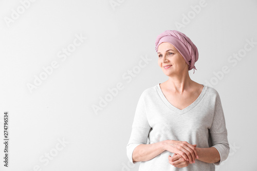 Mature woman after chemotherapy on light background photo