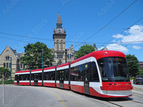 Long articulated streetcar bends as it goes around a curve photo