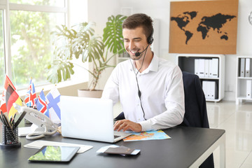 Male travel agent working in office