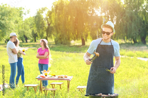 Man cooking tasty food on barbecue grill at party outdoors