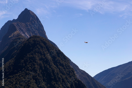 Milford Sound, New Zealand - Mitre Peak is the iconic landmark of Milford Sound in Fiordland National Park. Summer midday. Plane flying around the mountain.