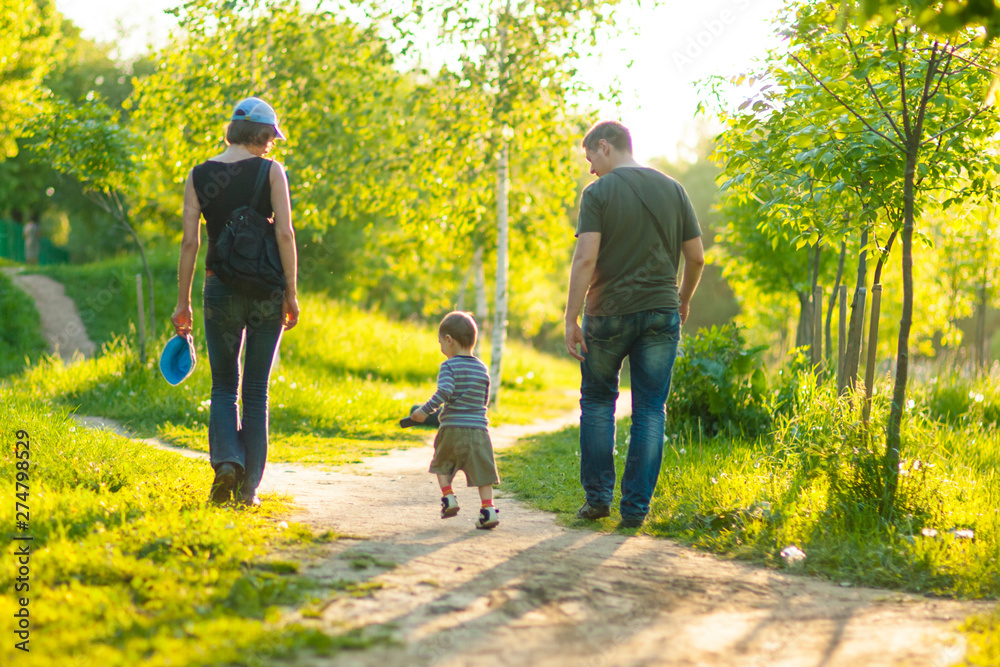 Obraz premium Portrait of Young Caucasian Family of Three Together Outdoors. Having a Stroll.