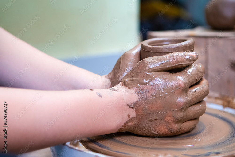 Hands of Experienced Female Potter Working with Clay Lump on Potter's Wheel in Workshop. Hands of Experienced Female Potter Working with Clay Lump on Potter's Wheel in Workshop.